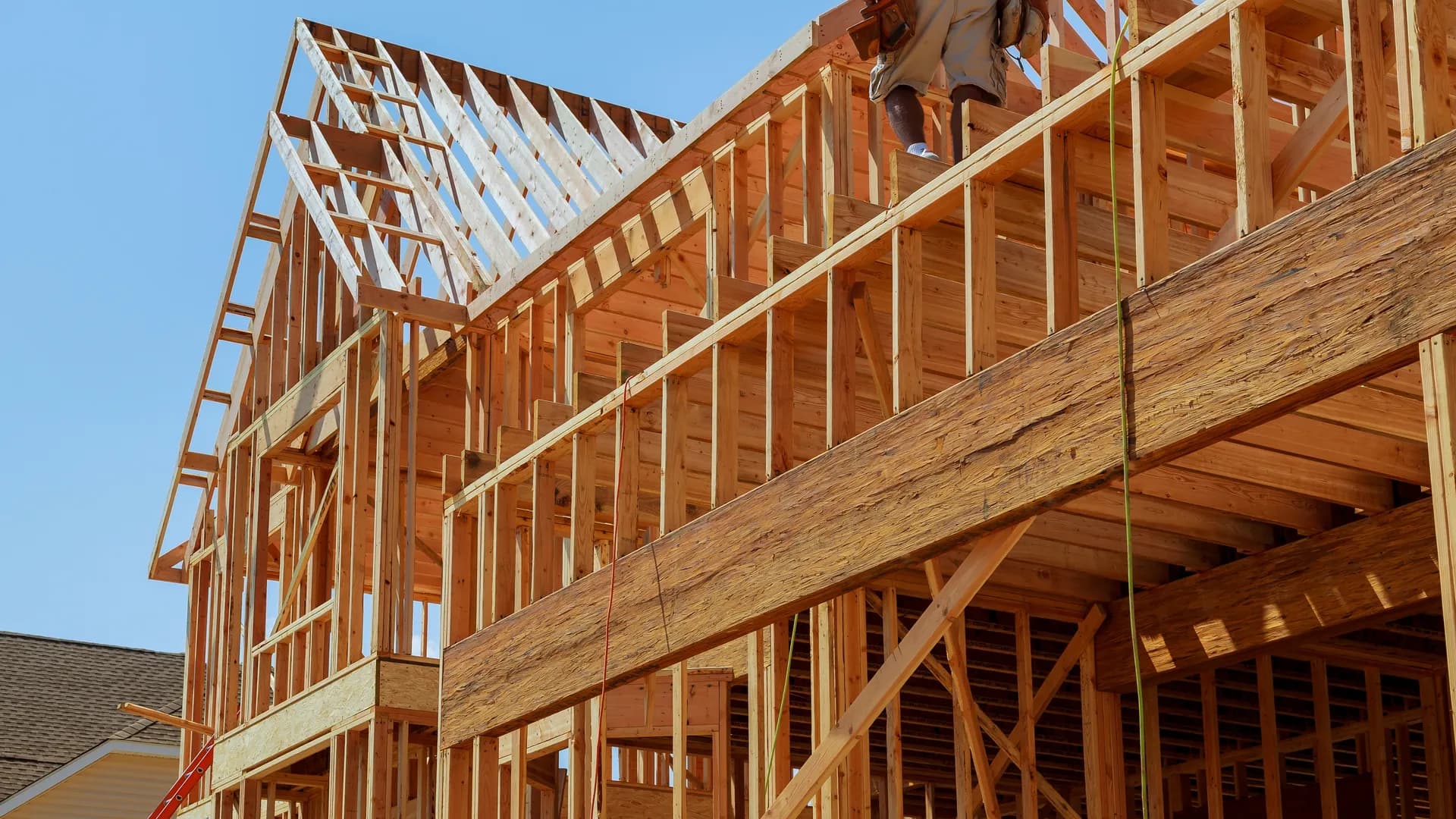 New residential roof construction framing in Utah County with exposed rafters and blue sky